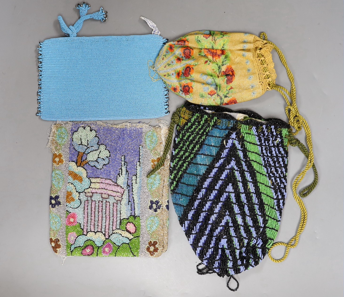 A late 19th century floral bead worked drawstring bag, a later jazz age beaded bag, a turquoise plain bead bag with zip and an unlined bead bag with a classical scene, (4)